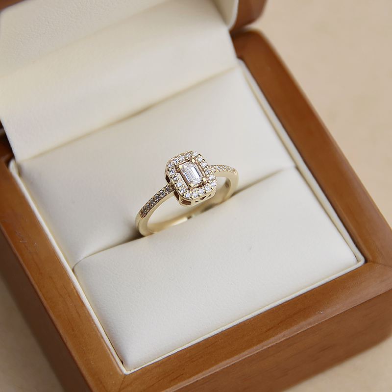 Pierścionek-zaręczynowy-z-żółtego-złota-z-diamentami-centralny-diament-o-szlifie-szmaragdowym-Diamentowa-Esencja-pudełko-1